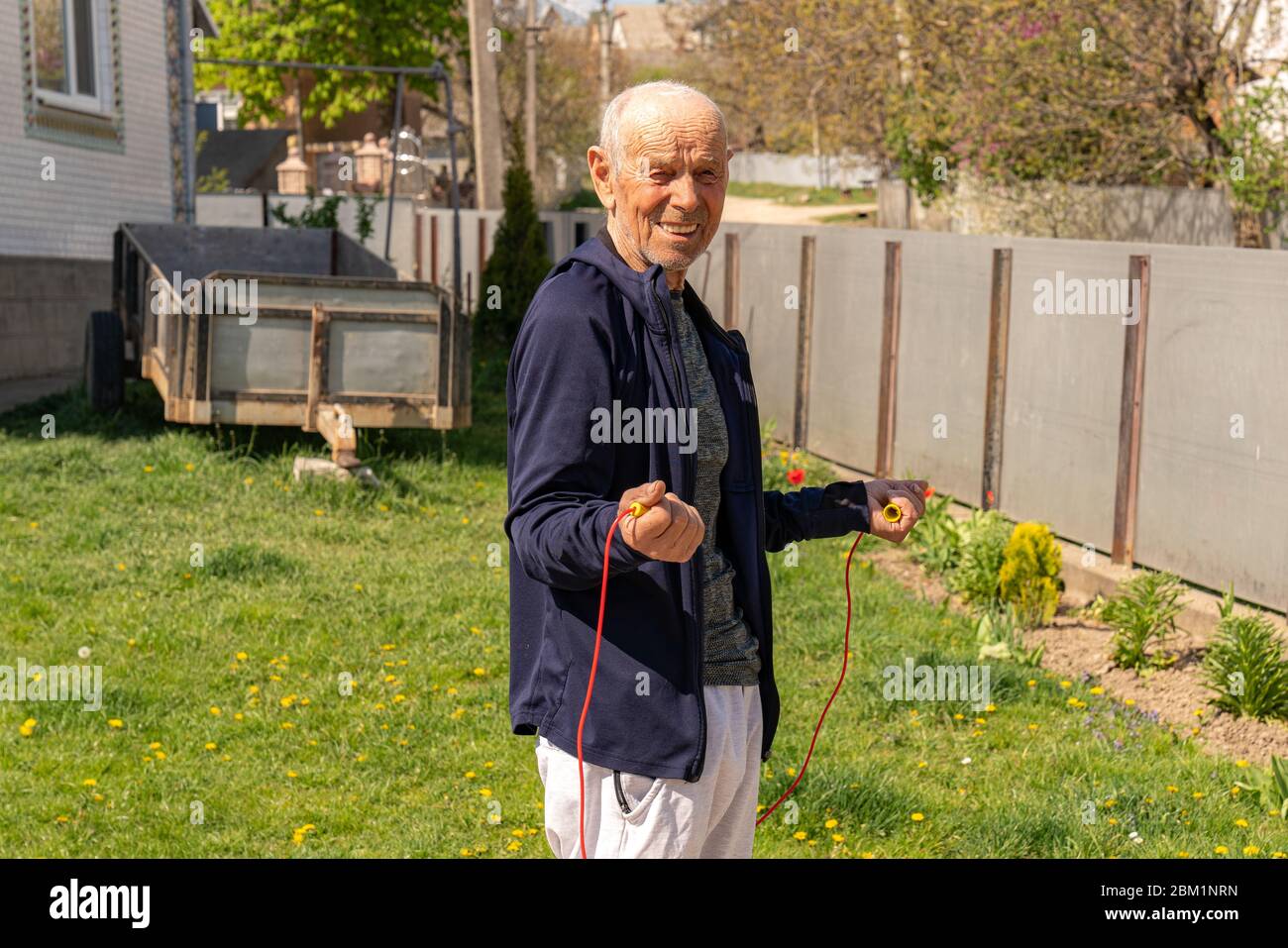 Cardio-Training im Freien. Alter athletischer Kerl springt mit Springseil Stockfoto