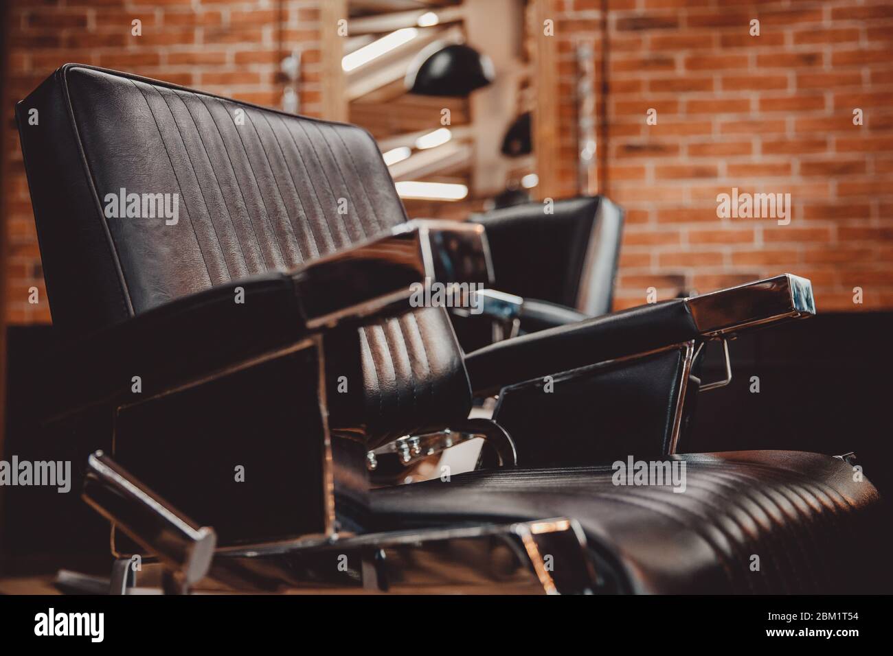 Vintage-Barbershop-Stuhl aus Leder, Ziegelwand. Concept Hipster Herren Friseursalon. Stockfoto
