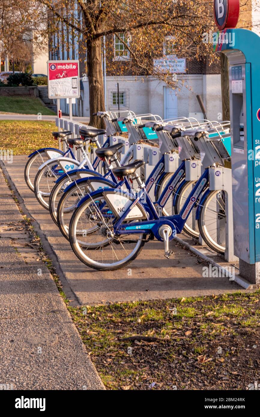 Charlotte, NC/USA - 26. Dezember 2019: Vertikale Aufnahme von öffentlichen Leihfahrrädern im Freien in einem Fahrradträger - sicherer Transport während der COVID-19. Stockfoto