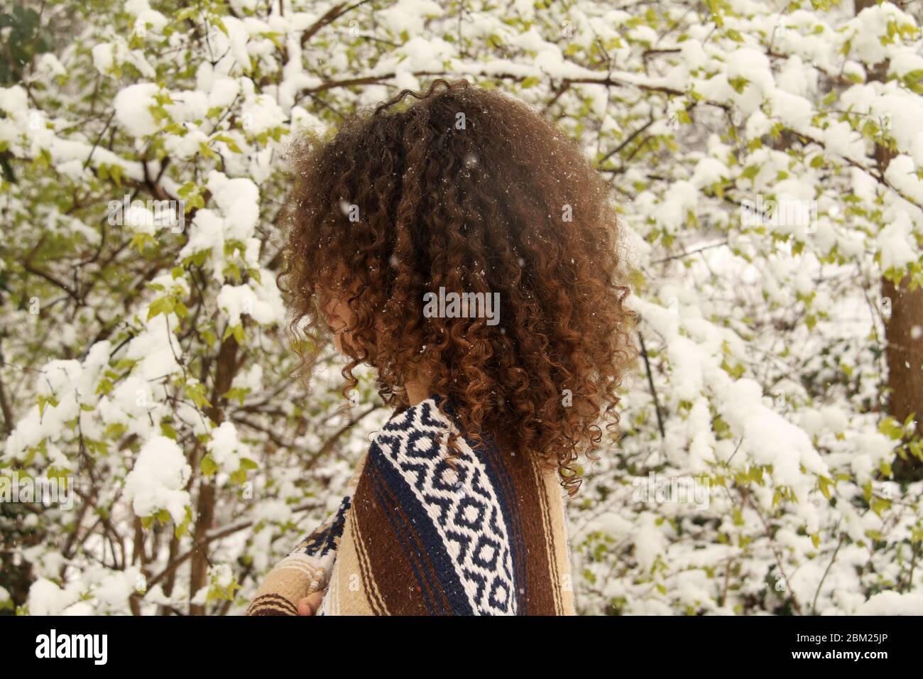 Ein junges Mädchen draußen im Hof während des Schneesturms Stockfoto