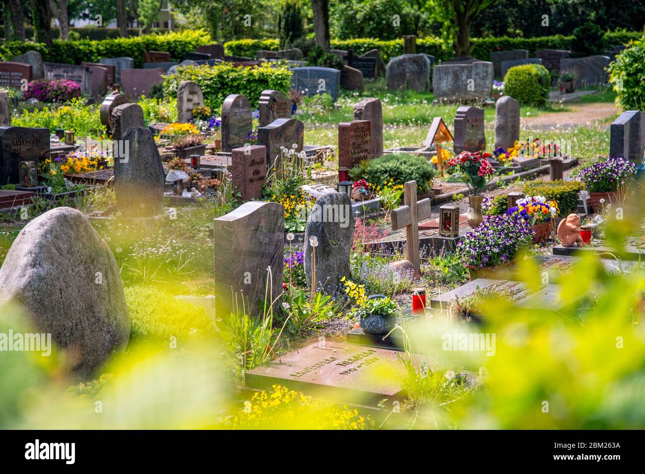Gräber mit Grabsteinen, Holzkreuze und Blumenschmuck auf dem alten Friedhof von Oberursel bei Frankfurt Stockfoto