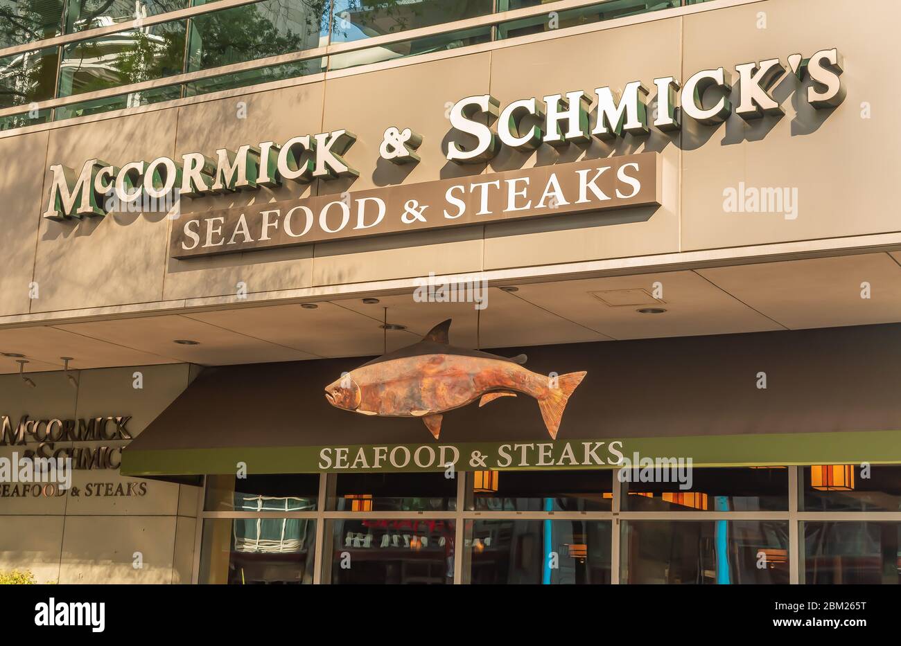 Charlotte, NC/USA - 26. Mai 2019: Fassade des Restaurants 'McCormick & Schmick's Seafood & Steaks' mit Marke in weißen Buchstaben und hängendem Fischschild. Stockfoto