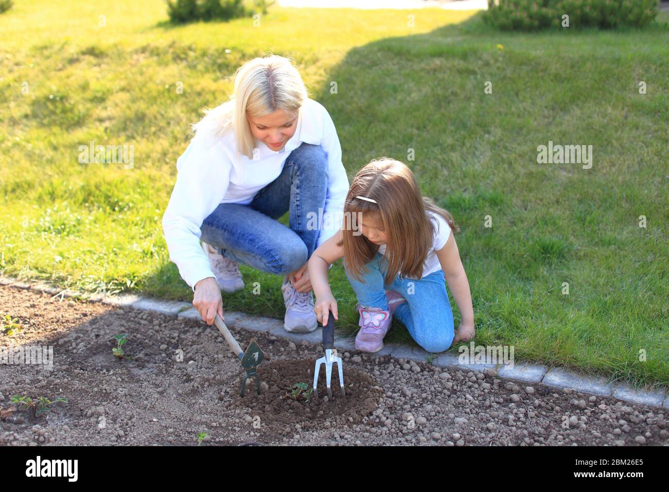 Mutter und Tochter arbeiten in Hacken in einem Garten Stockfoto