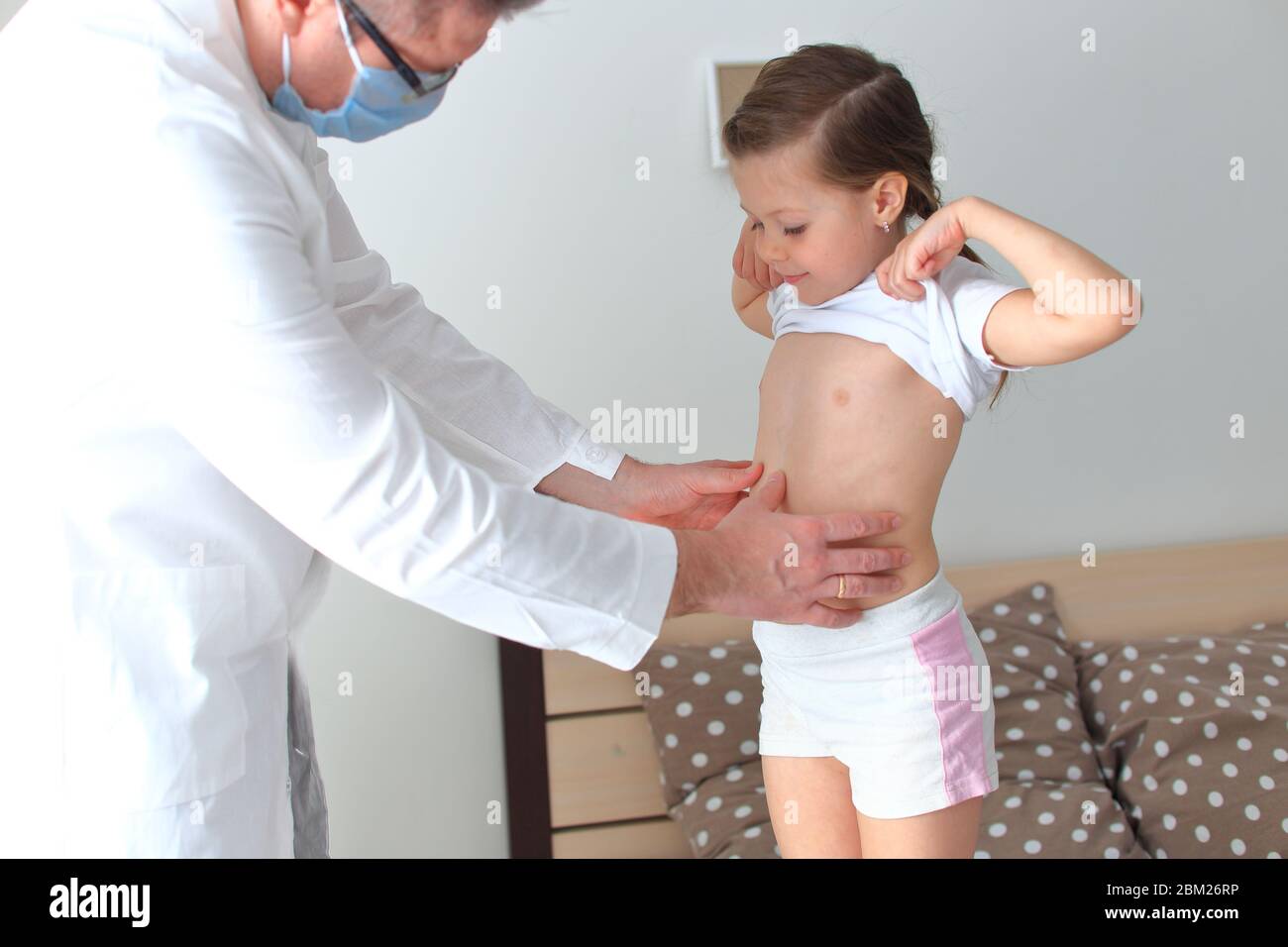 Doktor untersucht ein kleines Mädchen zu Hause Stockfoto