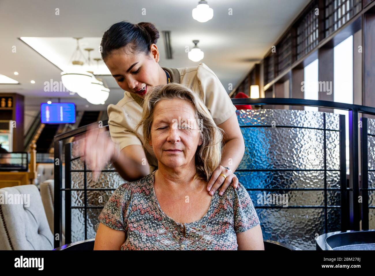 Eine weibliche Reisende, die EINE kostenlose Massage in einer Airport Lounge am Bangkok International Airport, Thailand. Stockfoto