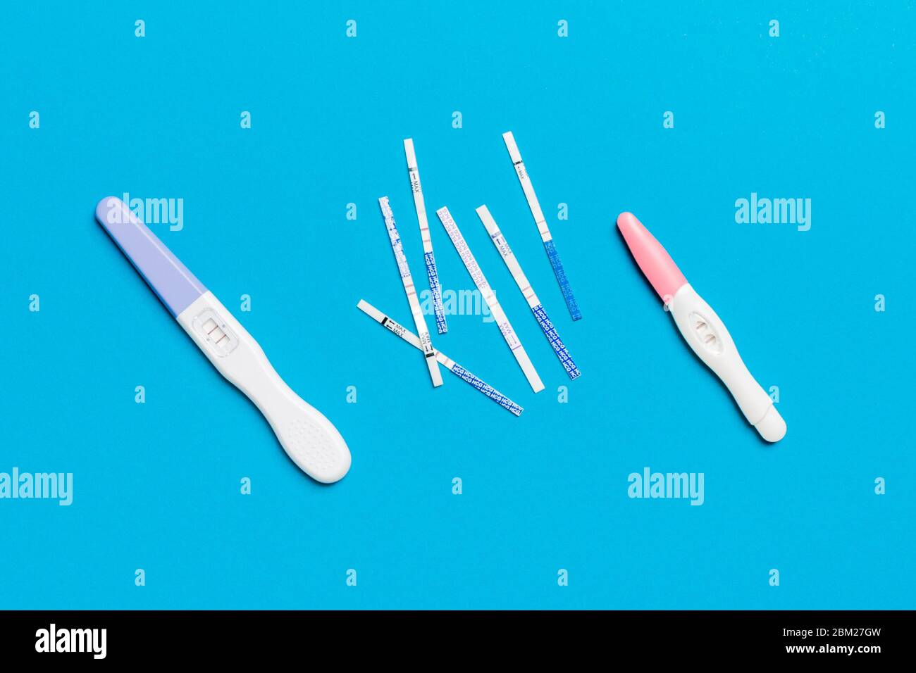 Farbiger Schwangerschaftstest auf farbigem Hintergrund, Draufsicht mit Kopierfläche. Stockfoto