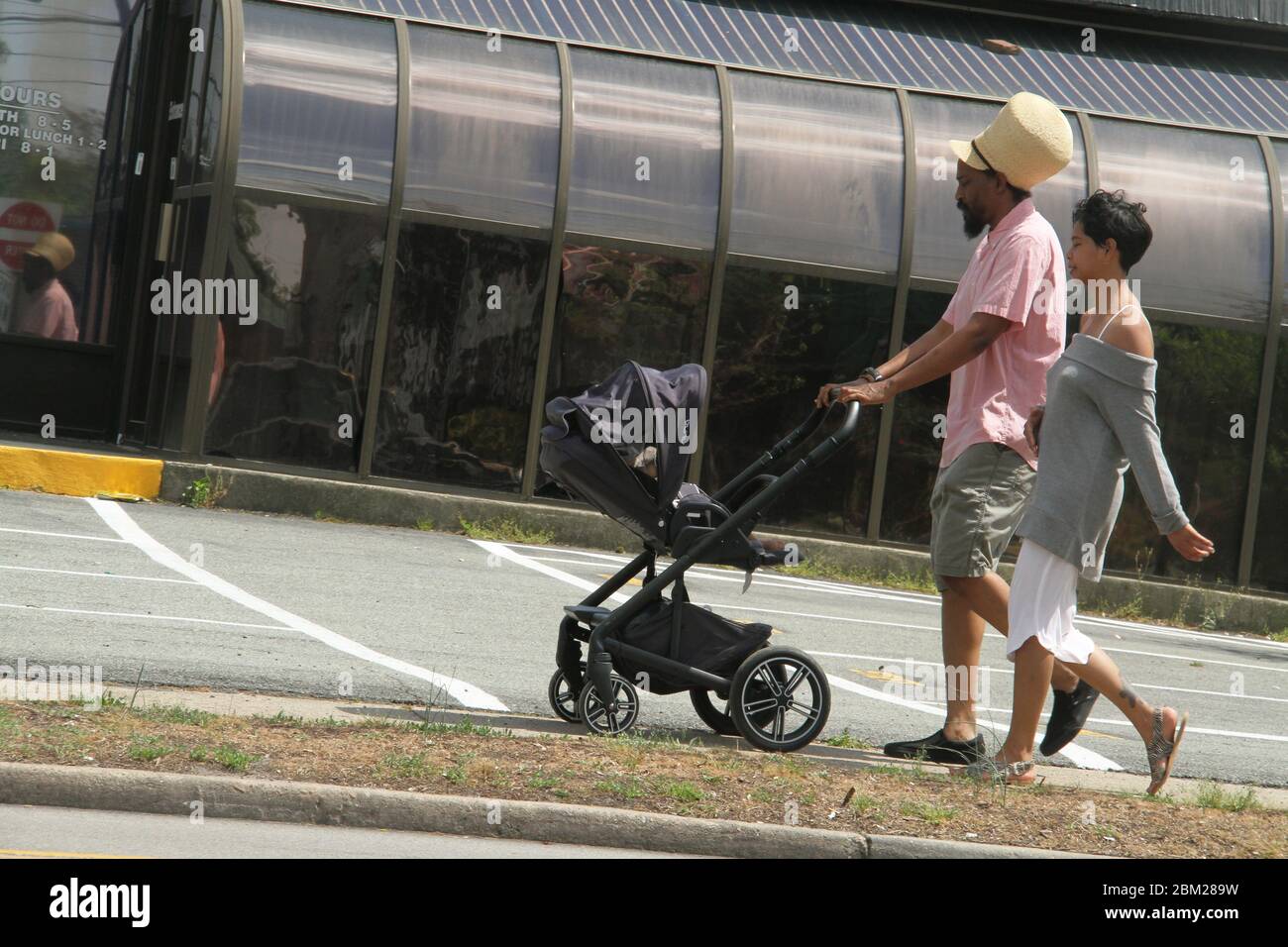 Gut aussehende amerikanische Paar einen Spaziergang mit Baby im Kinderwagen Stockfoto