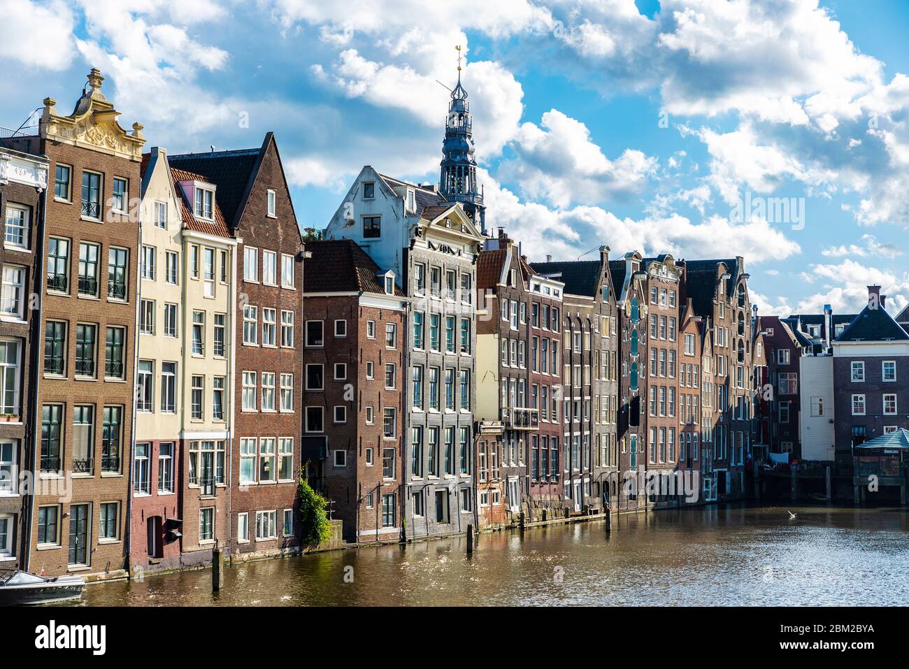 Alte traditionelle Schiefer Häuser entlang eines Kanals in der Damrak Waterfront, Amsterdam, Niederlande Stockfoto