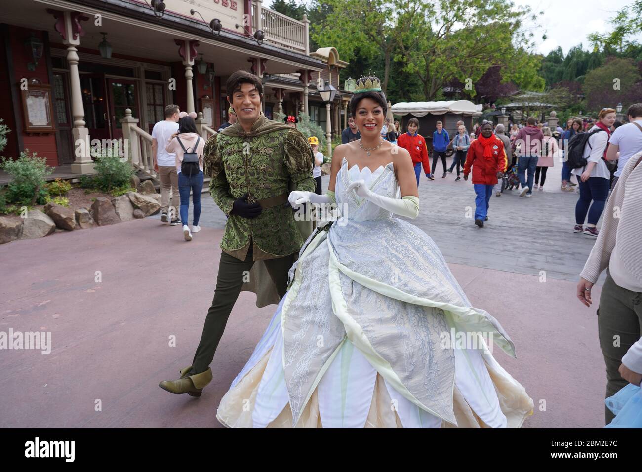 Schauspieler von Kiss the Frog gehen lächelnd als Tiana und Prinz Naveen durch die Straße des Themenparks in Disneyland. Paris Frankreich, 29. Mai 2019. Stockfoto