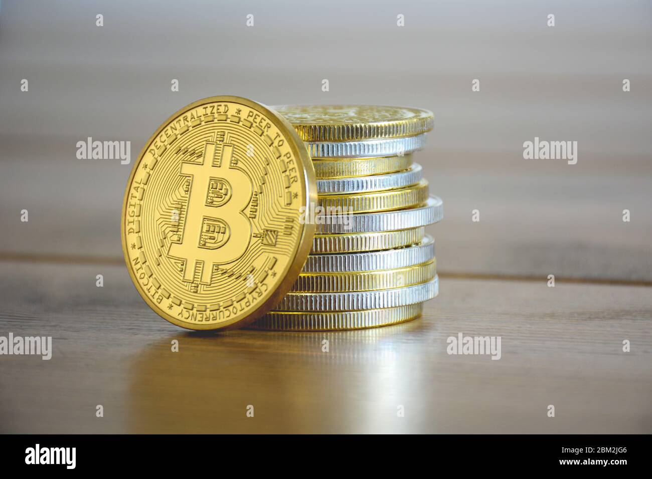 Stapeln Sie goldene und silberne Kryptowährungen zusammen. Vor ihm ist ein Goldbitcoin. Neue virtuelle Geldmünzen Stockfoto