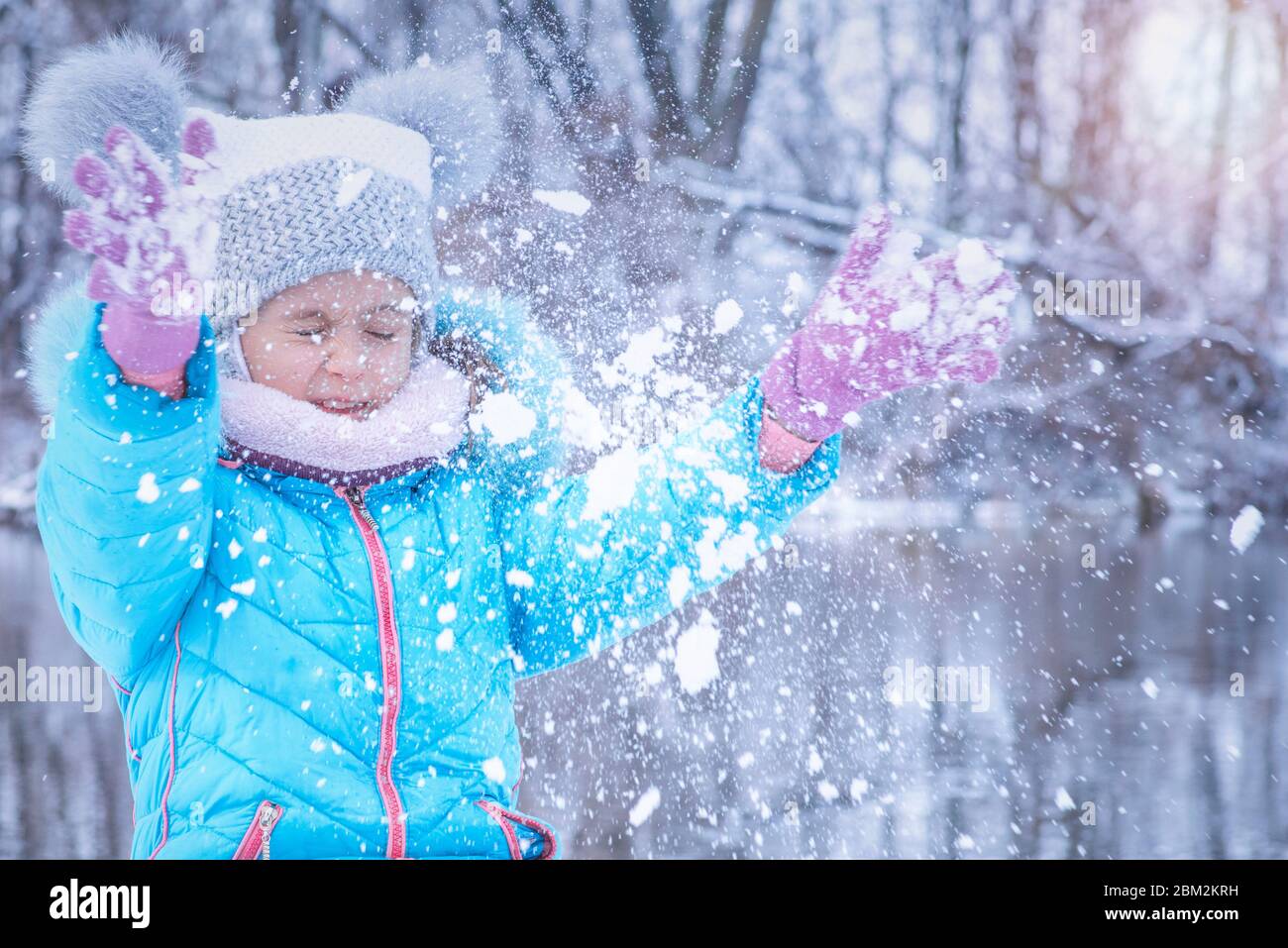 Winter day.Girl wirft Schnee up.Joyful Mädchen an einem sonnigen Wintertag spielt Schneebälle. Stockfoto