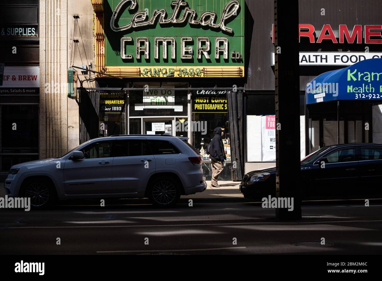 Eine Person, die eine Maske trägt, geht während der Bestellung zum Aufenthalt zu Hause am 1. Mai 2020 an Geschäften auf der Wabash Avenue in Chicago vorbei. Stockfoto