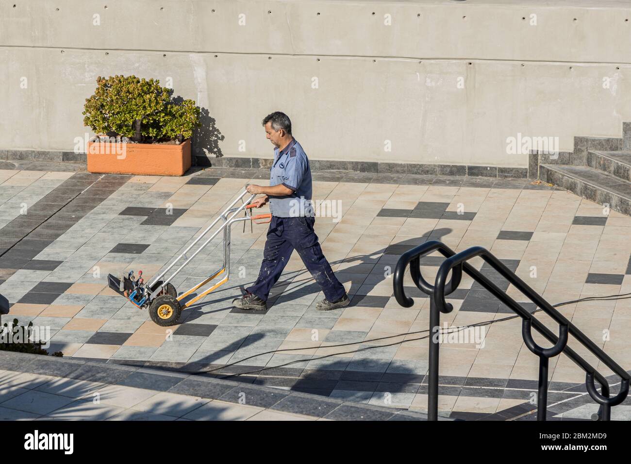 Wartungspersonal schiebt Sackkarren, Trolley im kommerziellen Zentrum Litoral in Fanabe während des Notstands von Covid 19 auf Teneriffa, Kanarische Isla Stockfoto