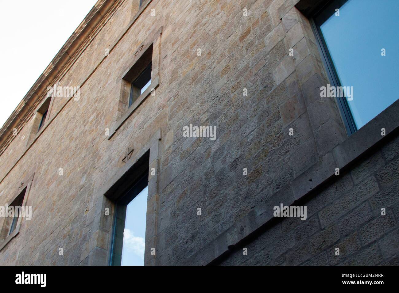 Antike Steinmauer mit Spiegelfenstern (Gotisches Viertel, Barcelona) Stockfoto