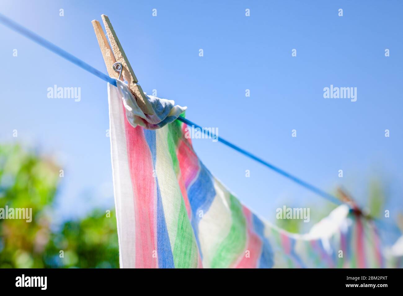 Frisch gewaschene Handtücher oder Laken hängen zum Trocknen an einer Wäscheleine. Stockfoto