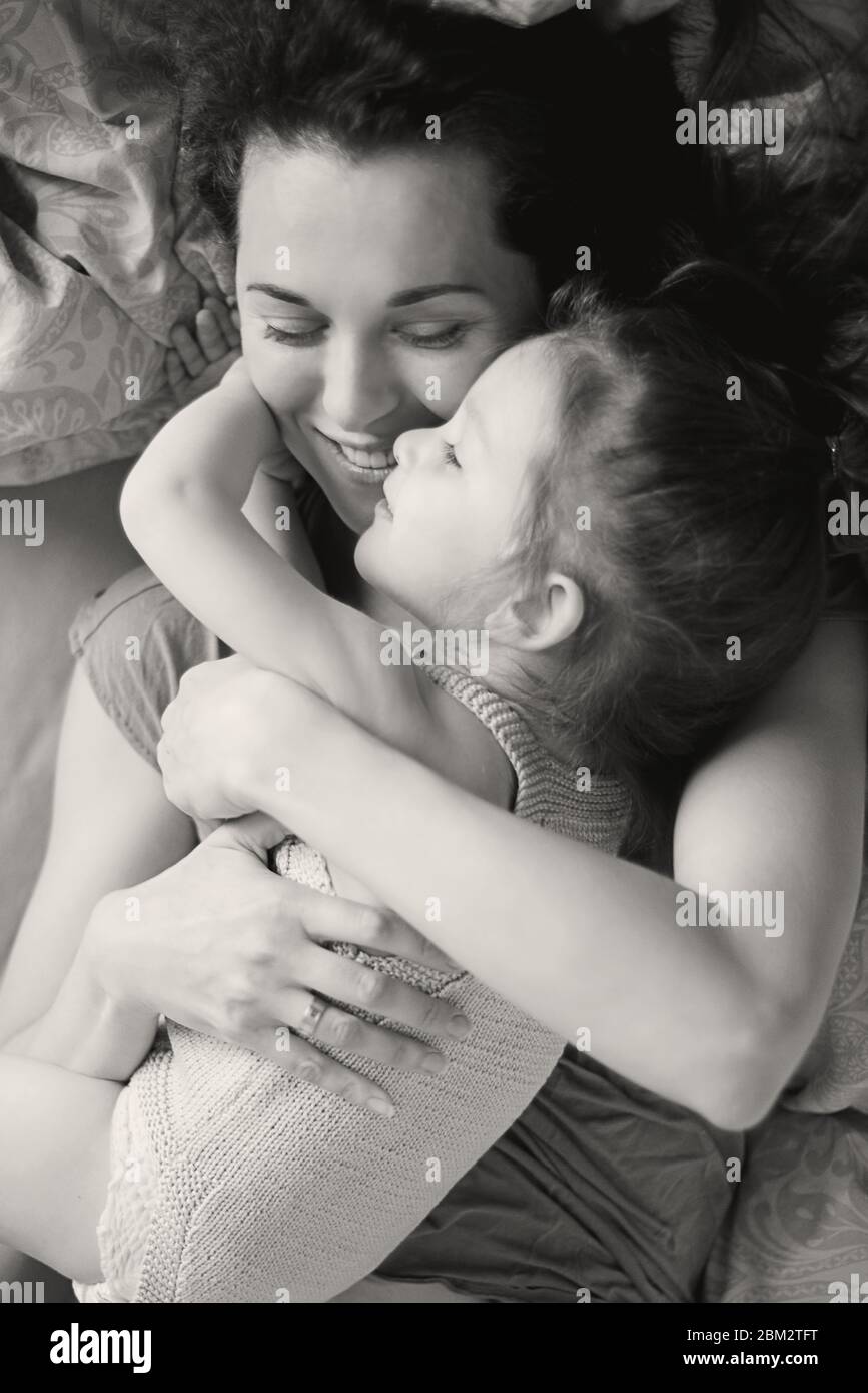 Mutter kuschelte Tochter im Bett Stockfoto