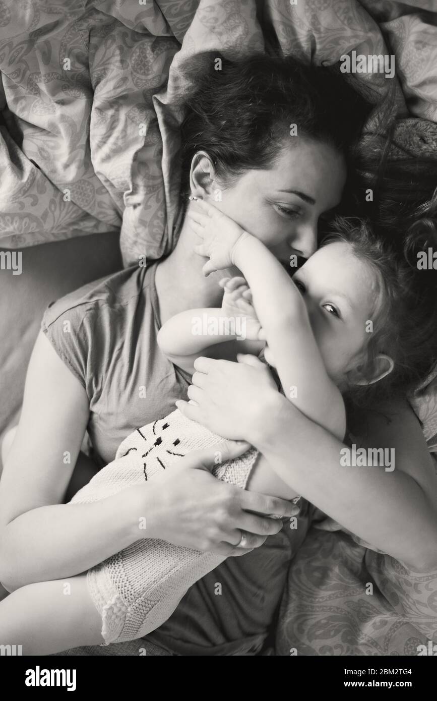 Mutter kuschelte Tochter im Bett Stockfoto