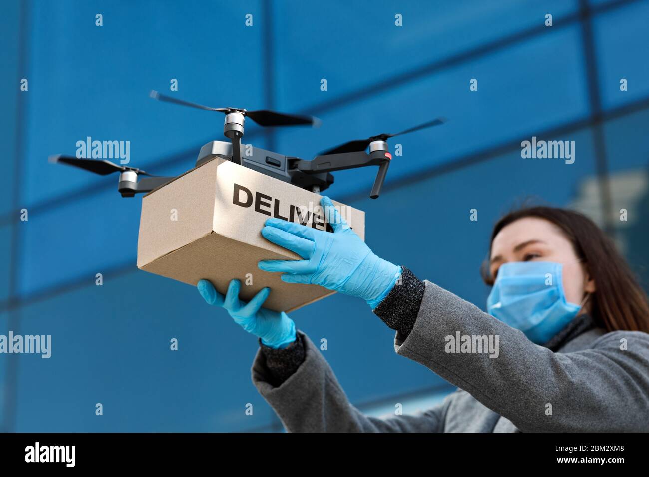 Drohne liefert braune Post Paket an Frau Arzt Stockfoto