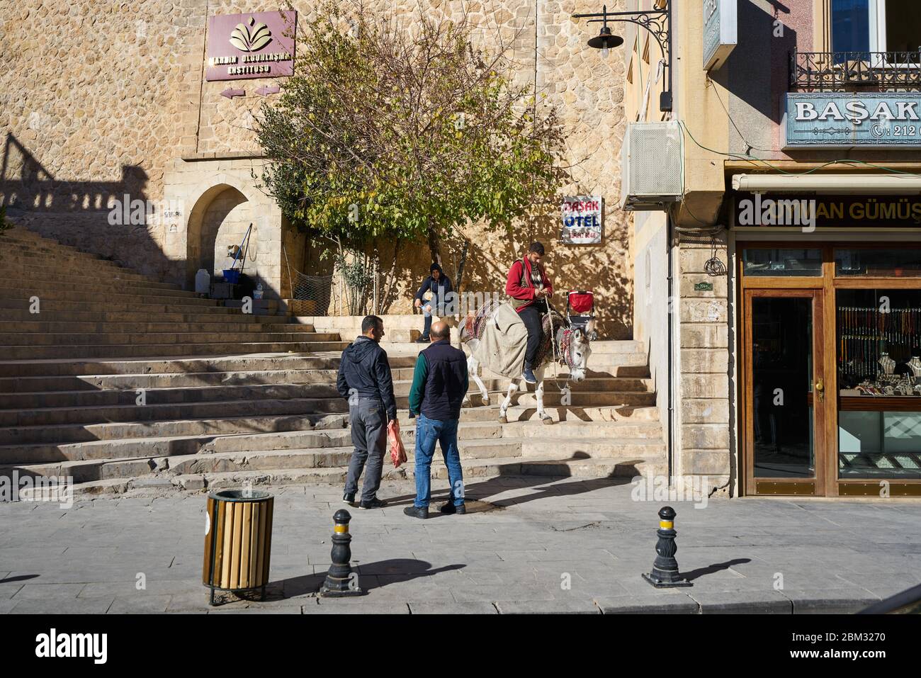 Mann reitet Esel / Maultier in engen Steinstraßen der alten Mardin, Türkei Stockfoto