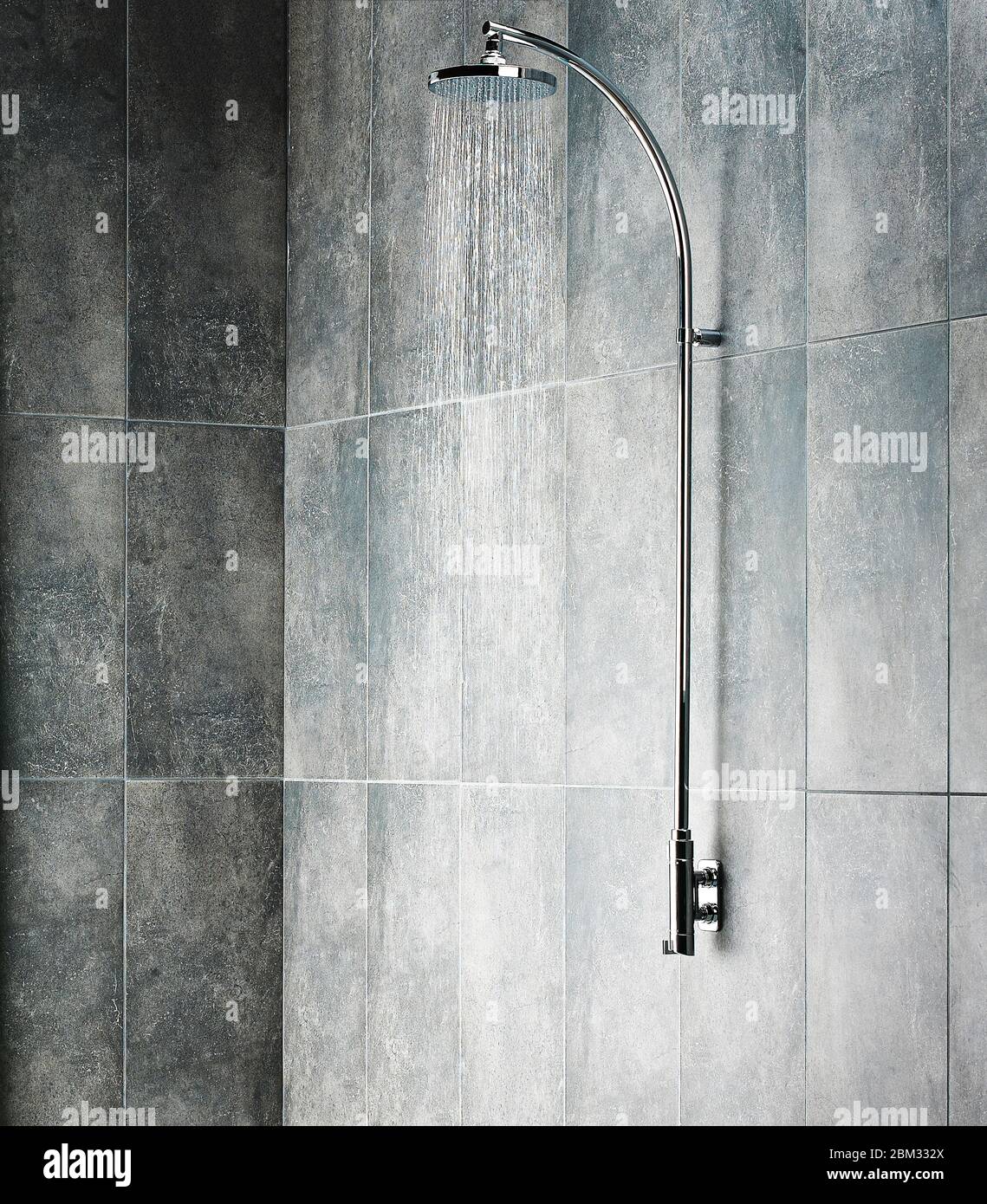 Fließendes Wasser aus dem Duschkopf in einer grauen Dusche im Badezimmer Stockfoto