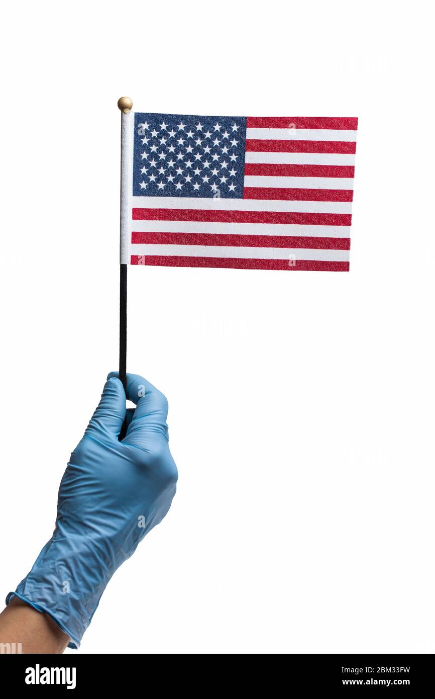 Handtragen Schutzhandschuh hält amerikanische Flagge isoliert auf weiß. Konzept des Pandemieausbruchs in den USA müssen die Menschen Gummihandschuhe tragen Stockfoto