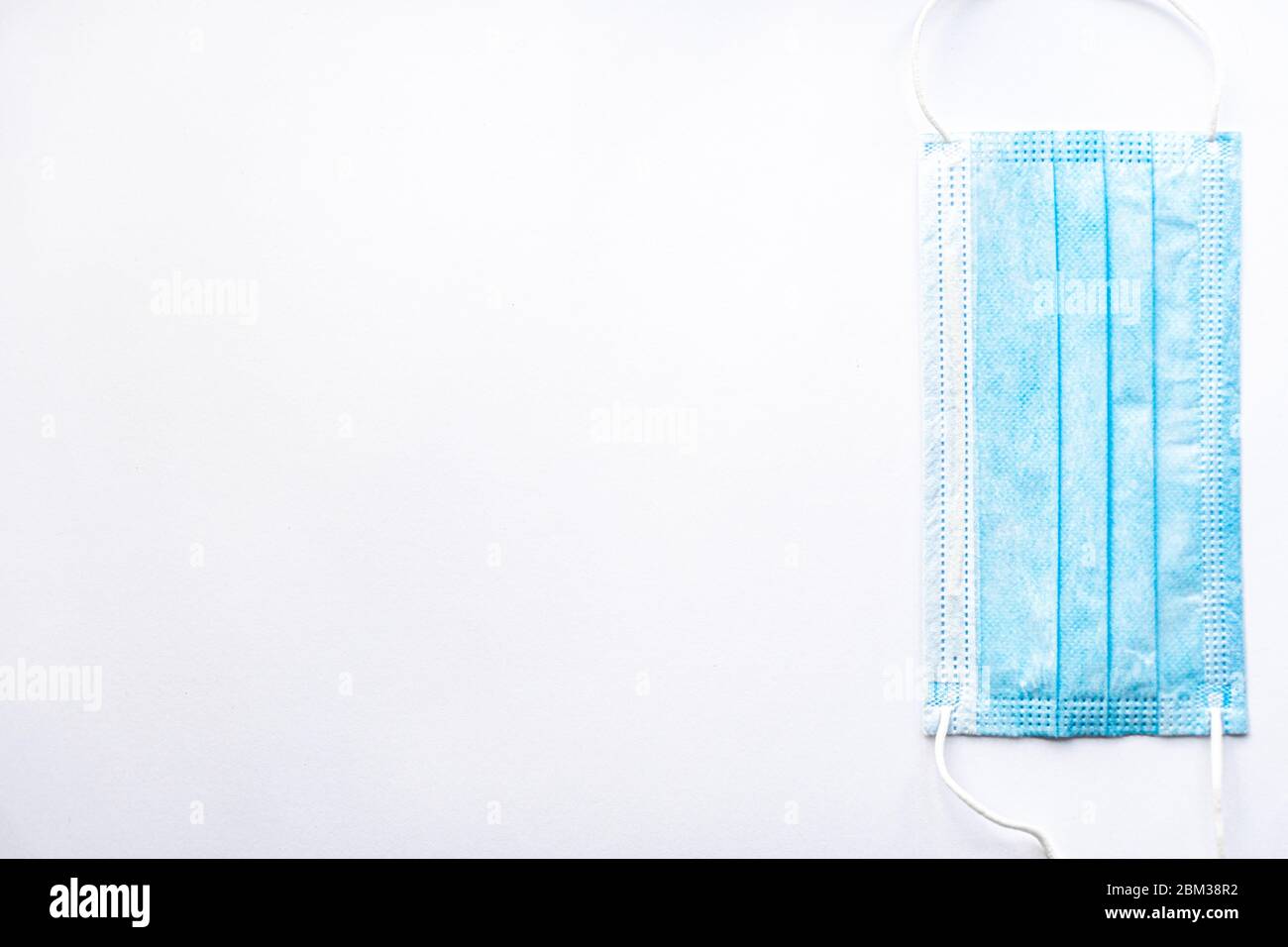 Medizinische blaue Einweg-Schutzmaske auf weißem Hintergrund kopieren Raum. Ein chirurgischer Verband schließt Mund und Nase. Gesundheitswesen, Medizin, Covid Stockfoto