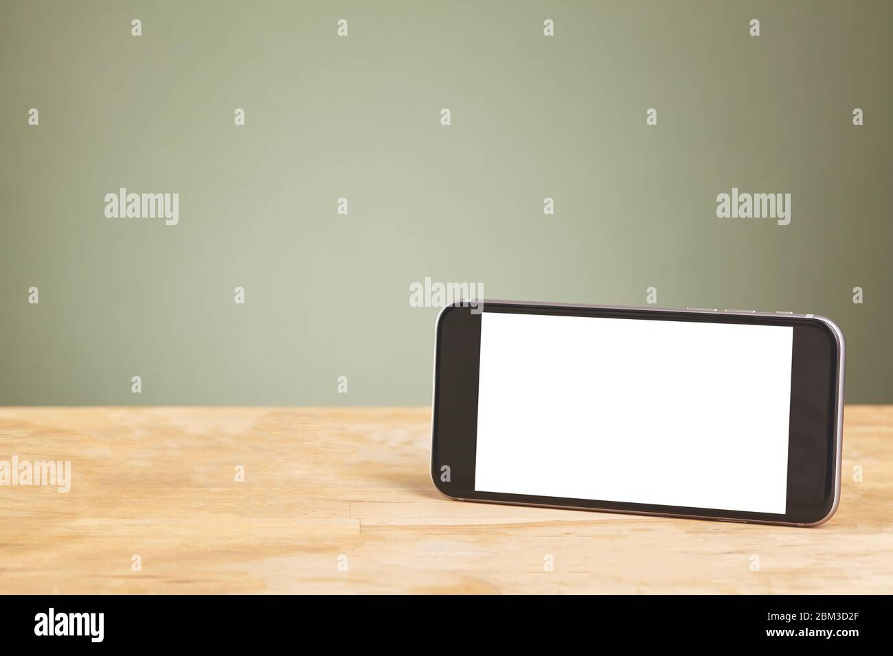 Smartphone mit isolierten Bildschirmen auf altem Holzschreibtisch. Stockfoto