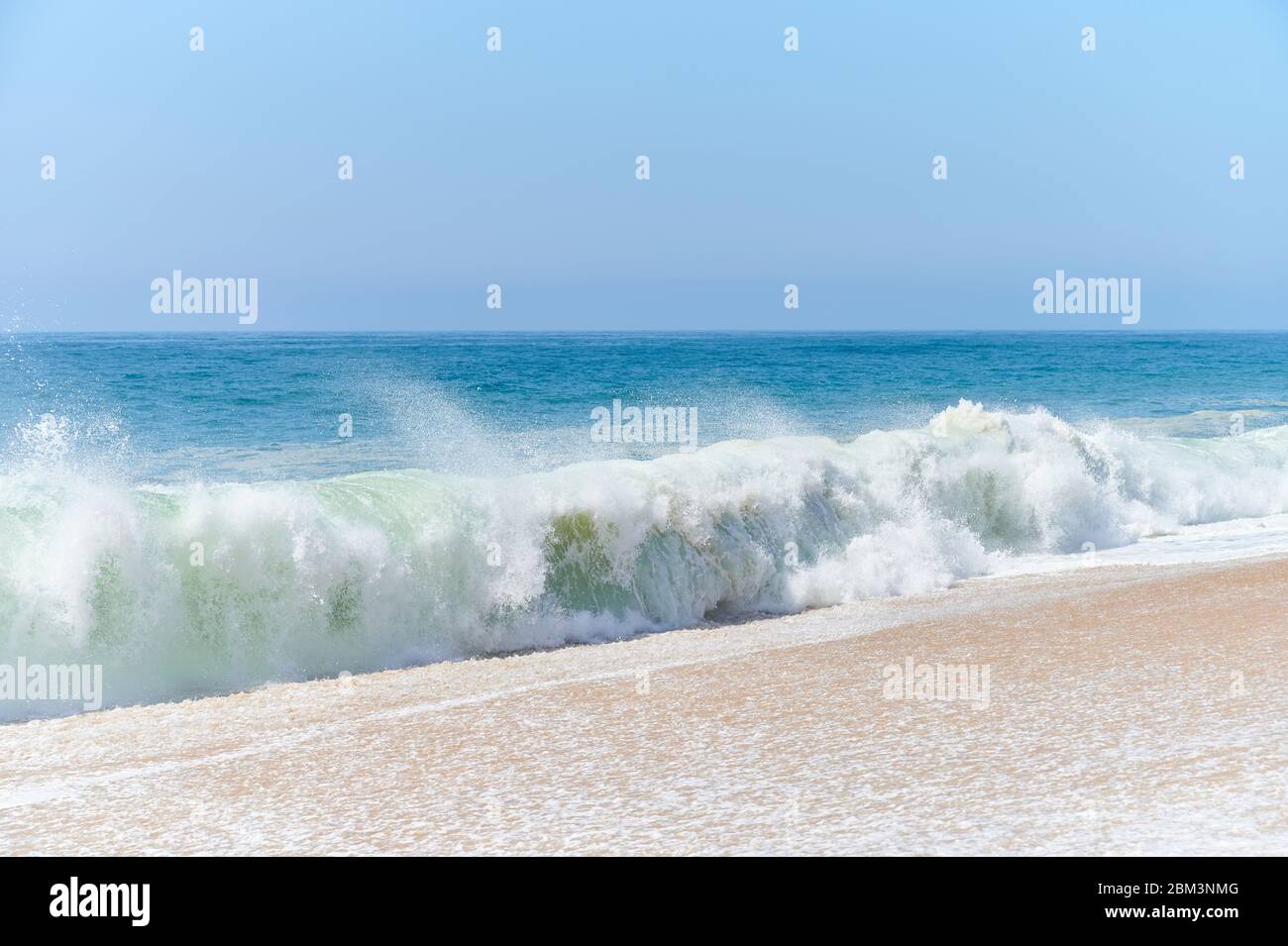 atlantische grüne Wellen schlagen am Strand am Nordstrand von Nazaré Stockfoto