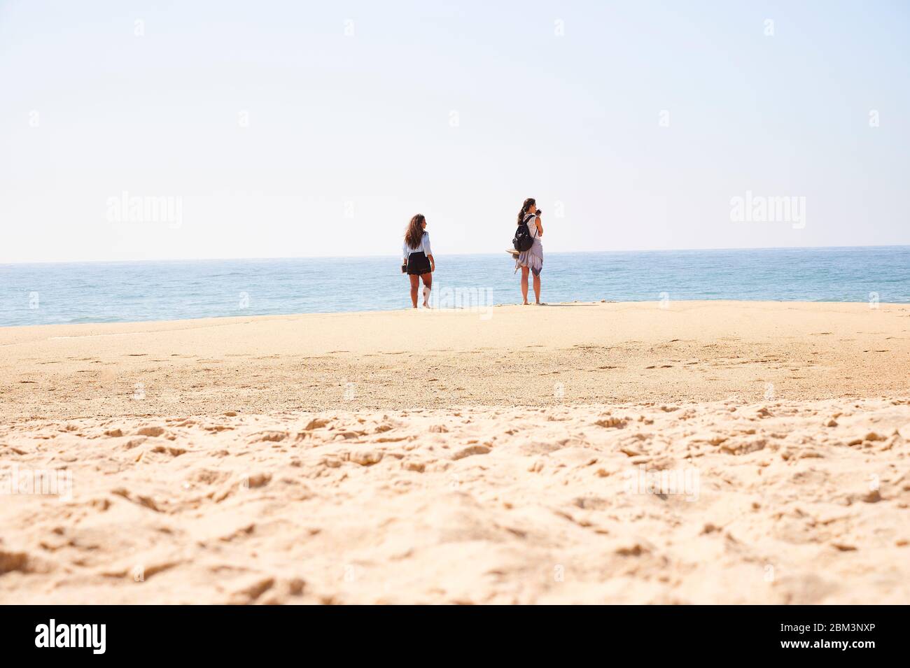 Zwei Freundinnen beim Entspannen am Strand von Norte Beach in Nazaré Stockfoto