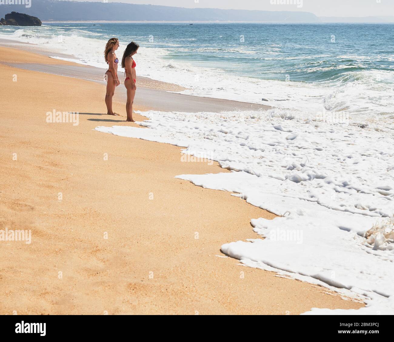 Zwei Freundinnen beim Entspannen am Strand von Norte Beach in Nazaré Stockfoto