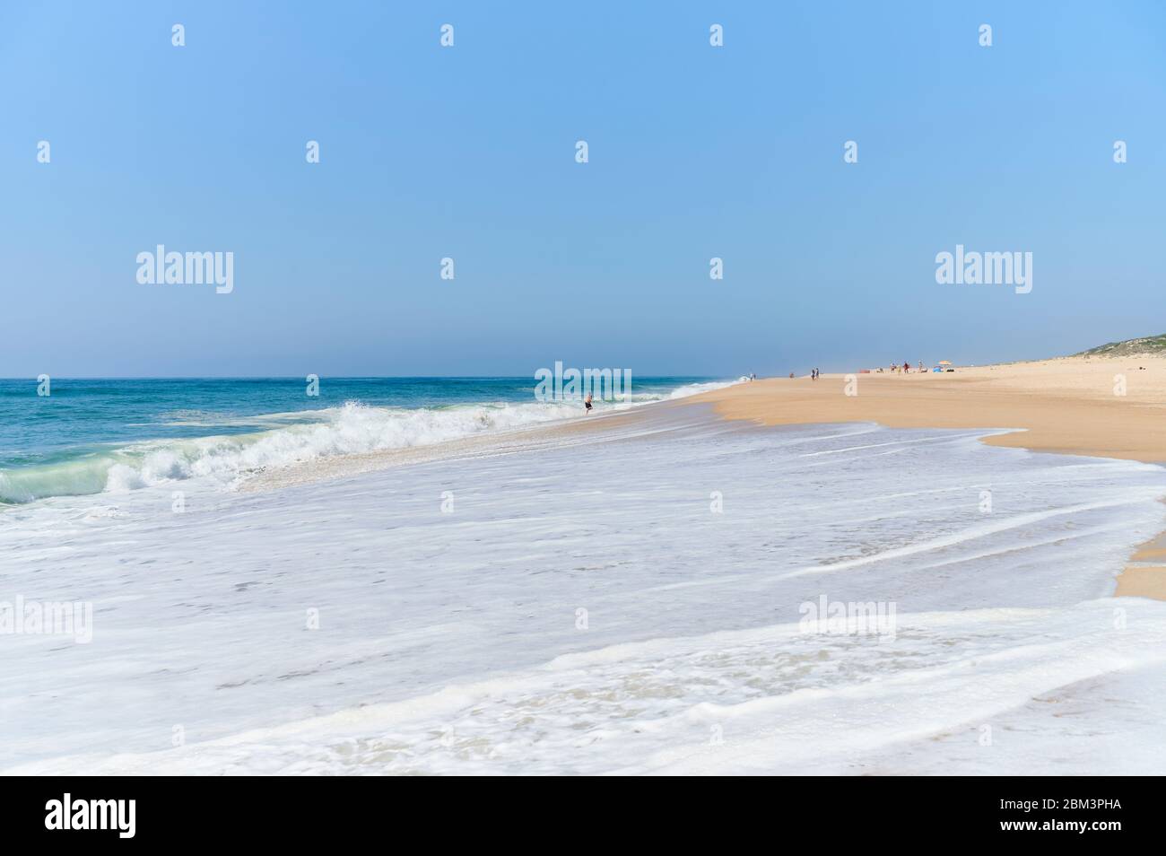 Langer Sandstrand an einem sonnigen Tag am Strand Nazaré norte Stockfoto