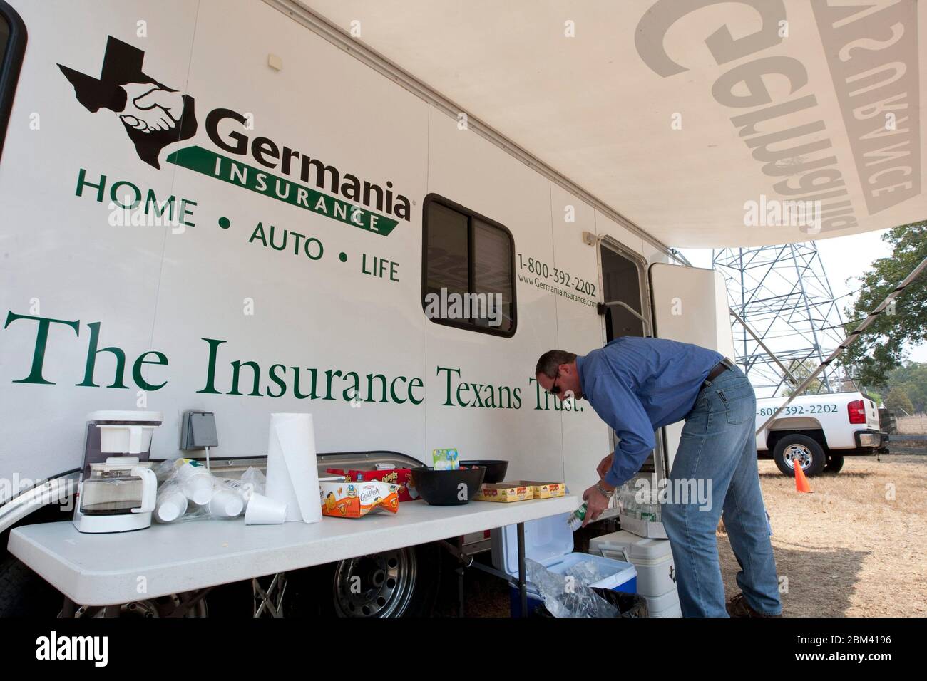 Bastrop Texas, USA, 7. September 2011: Ein Mitarbeiter der Versicherungsgesellschaft stellt eine Kaffeemaschine und Snacks bereit, während er ein temporäres Büro in einem Wohnwagen aufbaut. Das germanische Notfallteam wird Kunden mit Schadensfällen helfen, nachdem ein massiver Waldbrand durch die Gegend gefegt und mehr als 1.400 Häuser und Gebäude zerstört hat. ©Marjorie Kamys Cotera/Daemmrich Photography Stockfoto