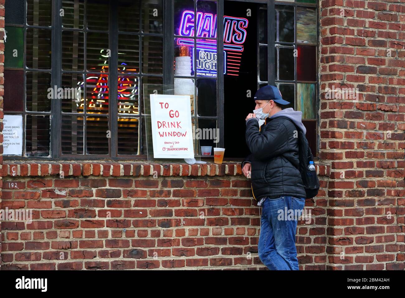 Ein 'To Go' Getränkefenster in 7B, Vazacs Horseshoe Bar in Manhattans East Village. Durch das Coronavirus... WEITERE INFORMATIONEN FINDEN SIE UNTER „VOLLSTÄNDIGE BILDUNTERSCHRIFT“ Stockfoto