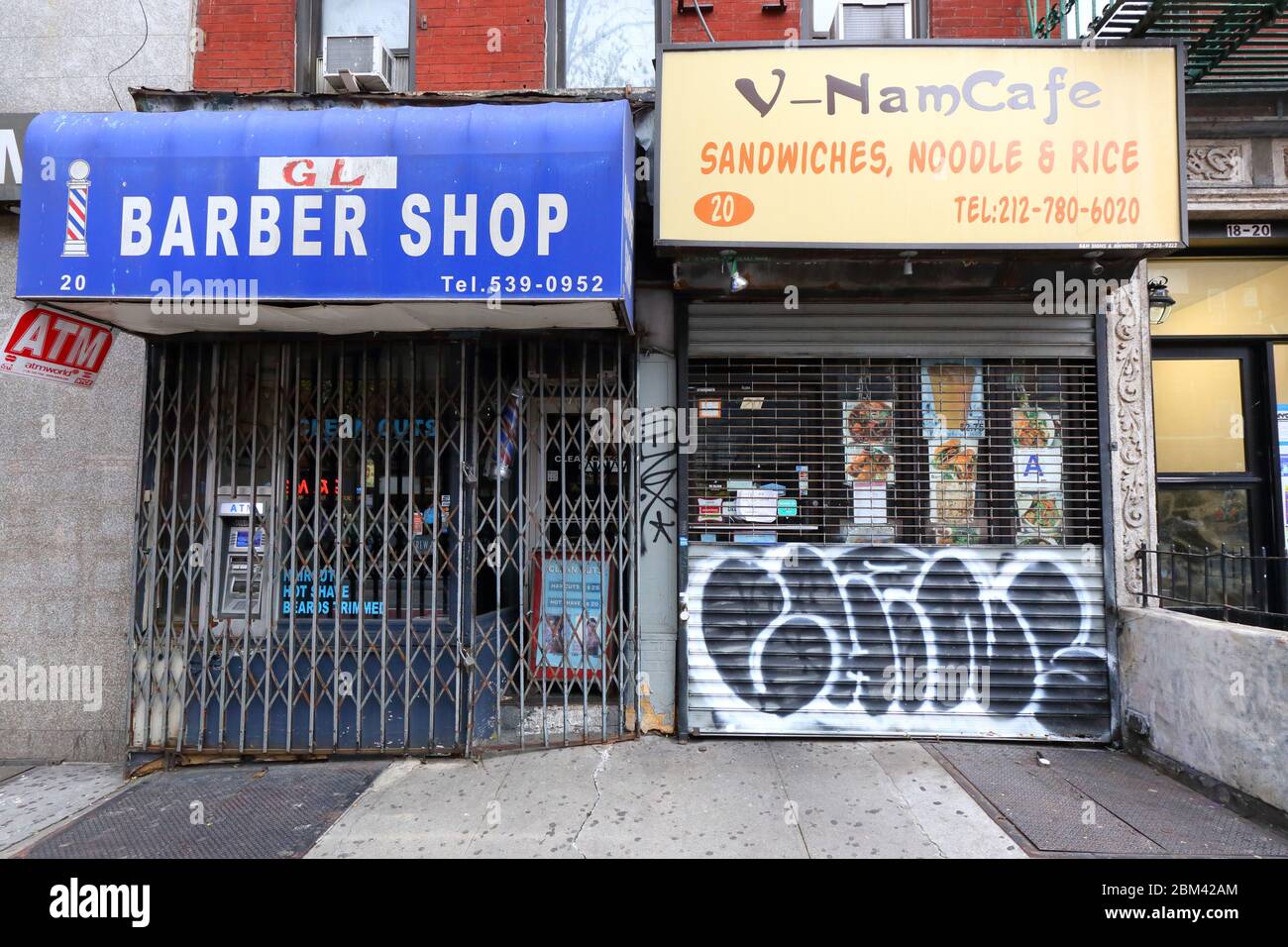 Zwei Shuttered-Geschäfte in New York City wegen der COVID-19-Krise. Ein Friseur, der als nicht wesentliche Geschäfte gelten. Und ein Restaurant Stockfoto