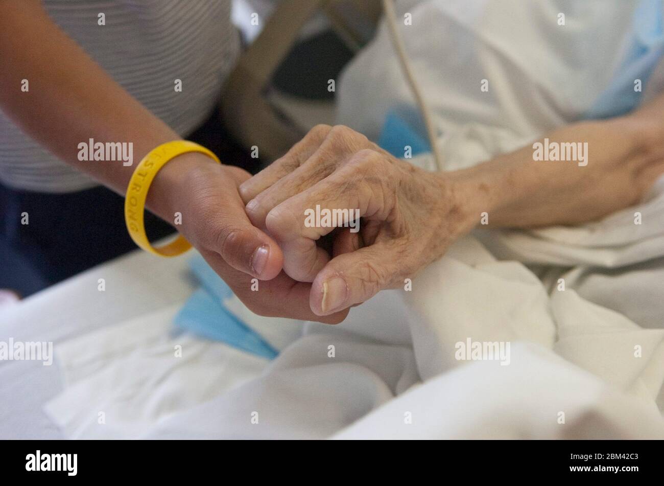 Burnet Texas USA, 26. Juni 2005: 73-jährige Anglo Frau mit unheilbarem Krebs hält die Hände mit Enkel im Krankenhaus. ©Bob Daemmrich Stockfoto