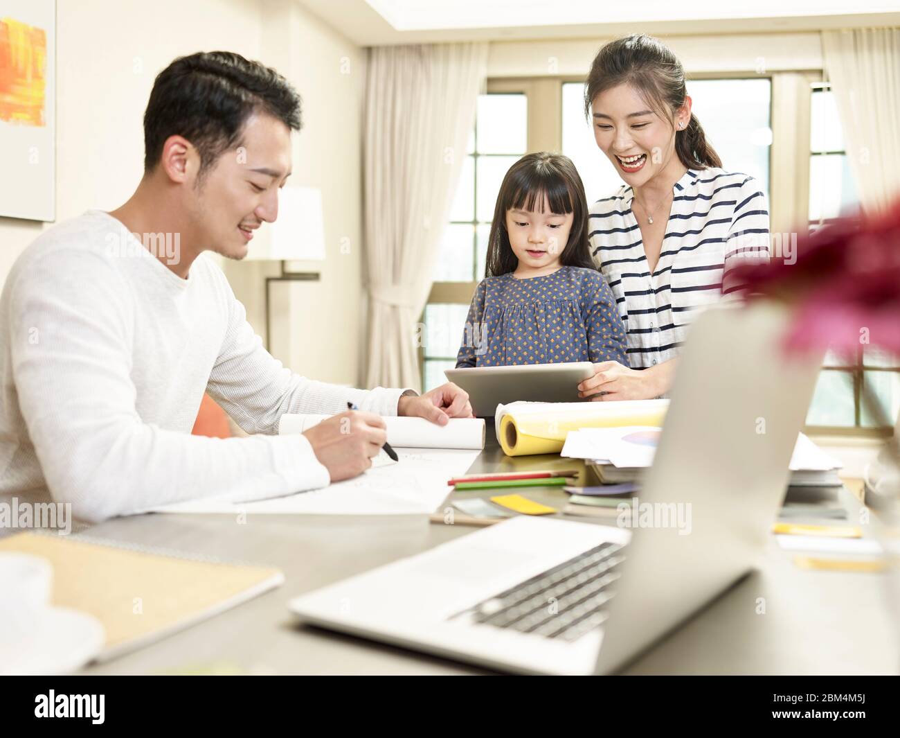 Junge asiatische Familie mit einem Kind zu Hause glücklich und fröhlich (Kunstwerk im Hintergrund digital verändert) Stockfoto