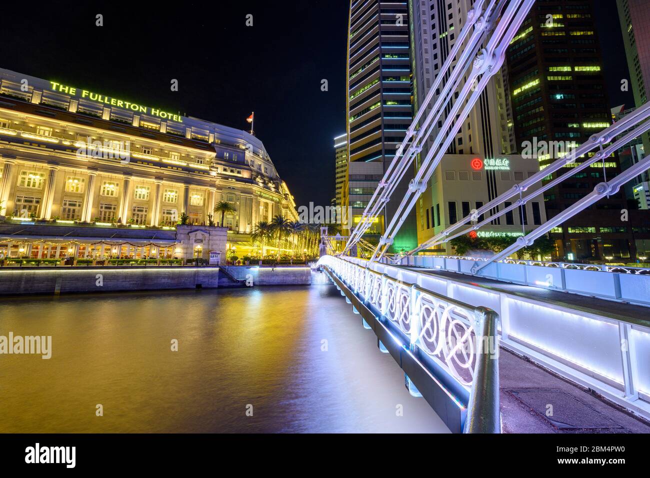 Singapur 30. Dezember 2019 : Cavenagh Bridge bei Nacht, im Hintergrund das Fullerton Hotel Stockfoto