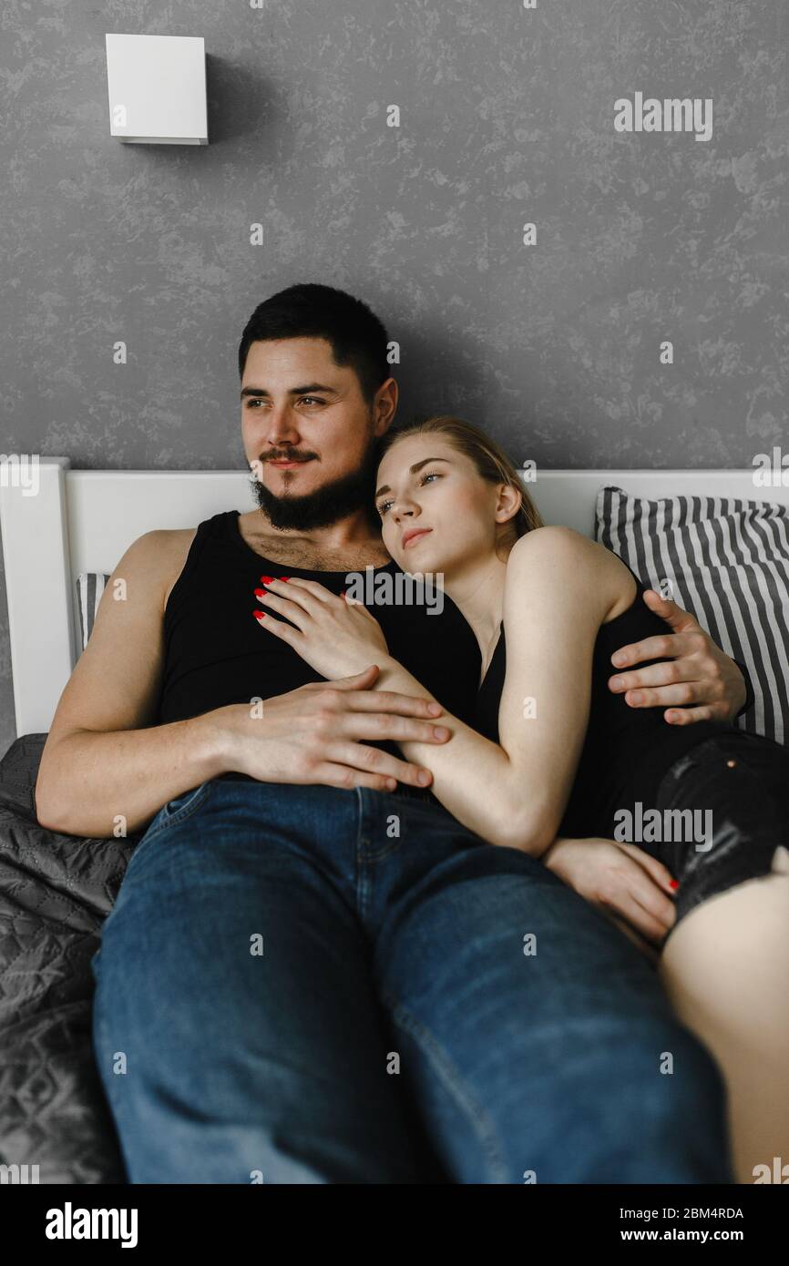 Frau und Mann liegen zusammen auf dem Bett und schauen zur Seite. Bleib zu Hause Stockfoto