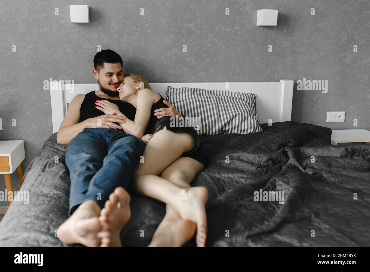 Frau und ihr Mann liegen auf dem Bett. Bleib zu Hause Stockfoto