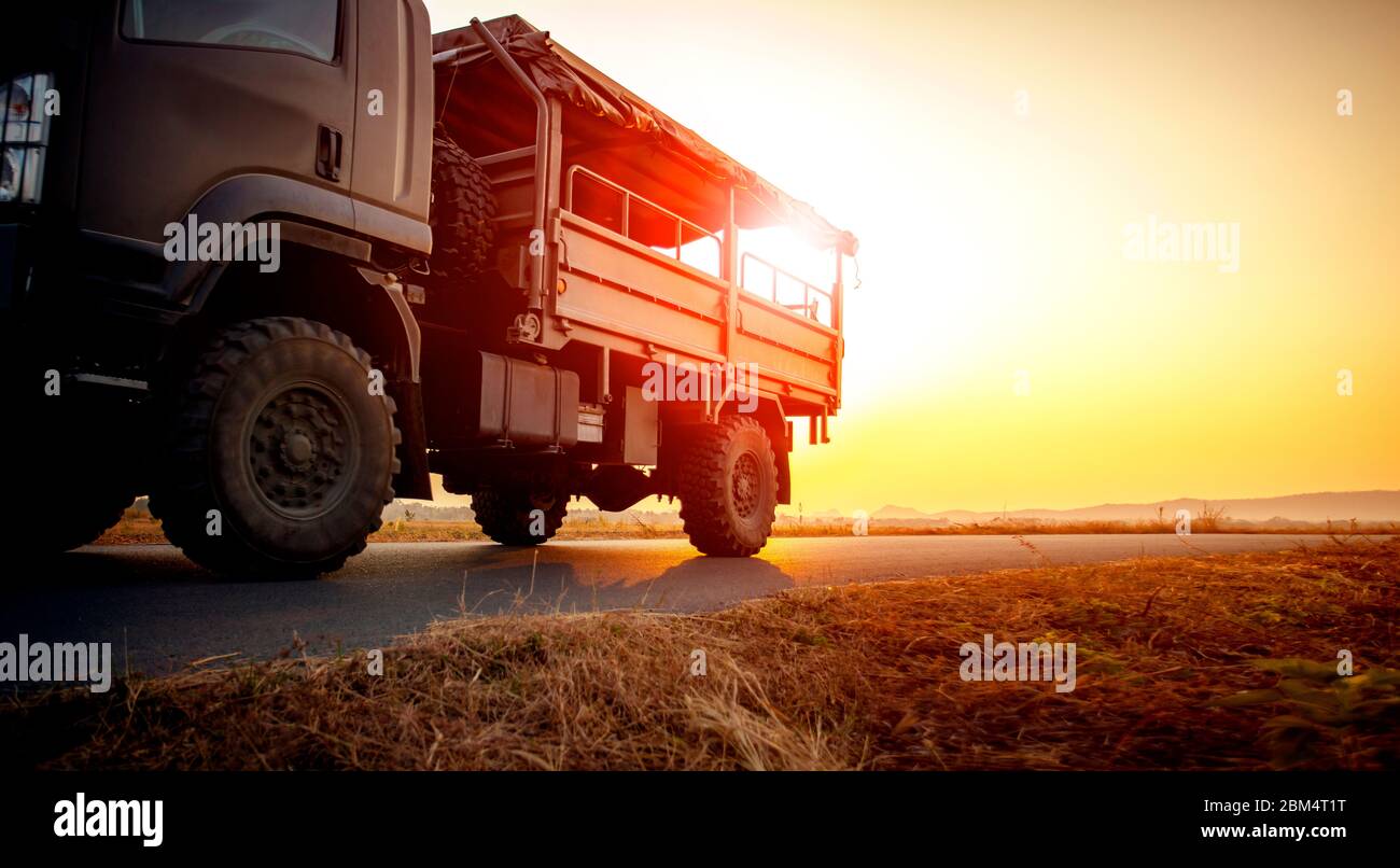 Militär LKW läuft auf Asphalt Autobahn gegen schönen Sonnenuntergang Himmel Stockfoto
