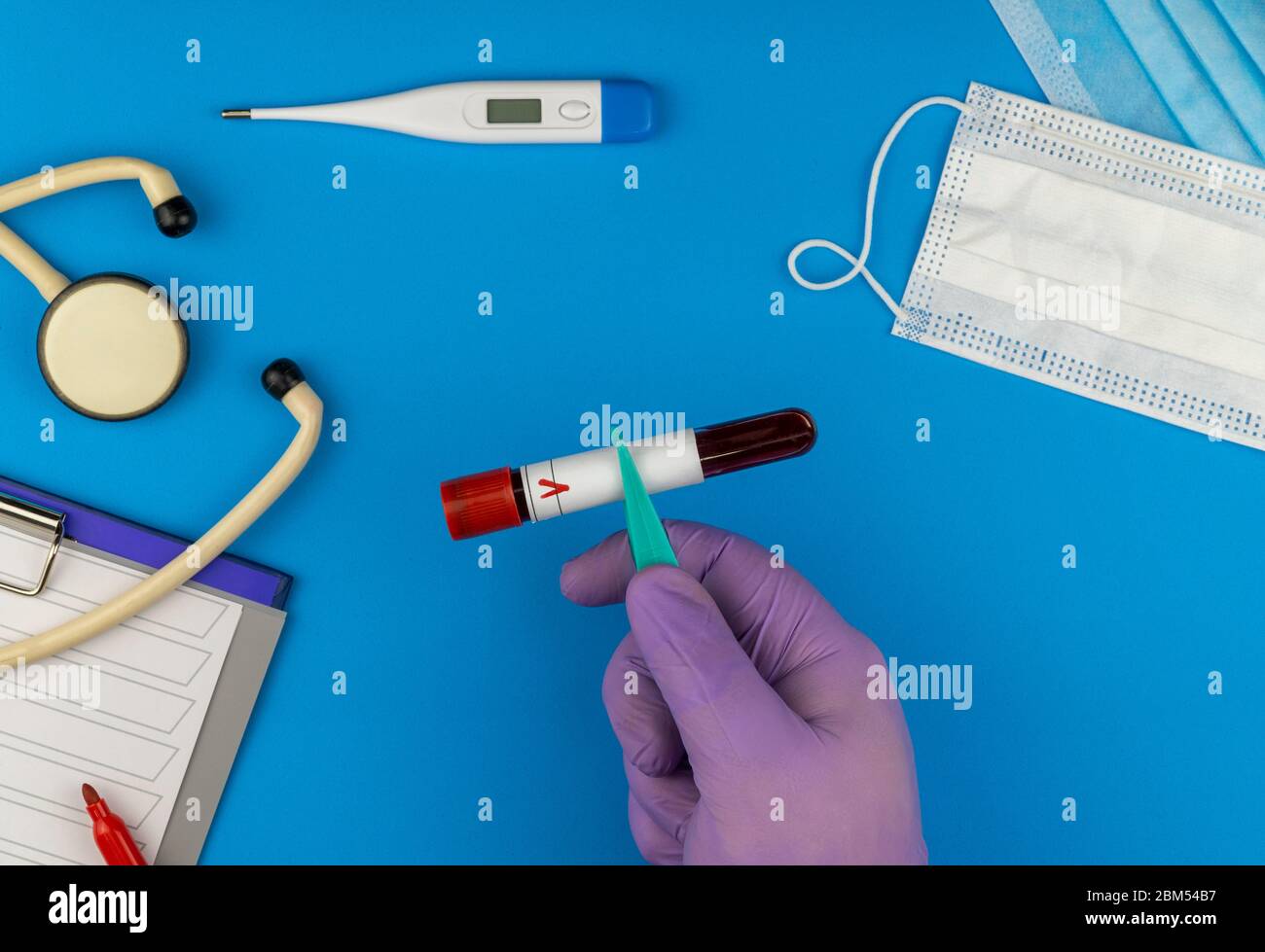 Flache Lay-Zusammensetzung mit Blutprobe auf blauem Hintergrund. Antivirale medizinische Maske zum Schutz vor Coronavirus Stockfoto