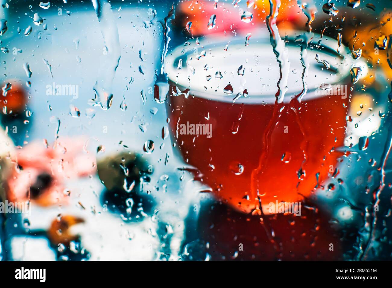 Herbsttee in einem transparenten Becher. Blätter. Regentropfen. Schöne atmosphärische Herbstkarte Stockfoto