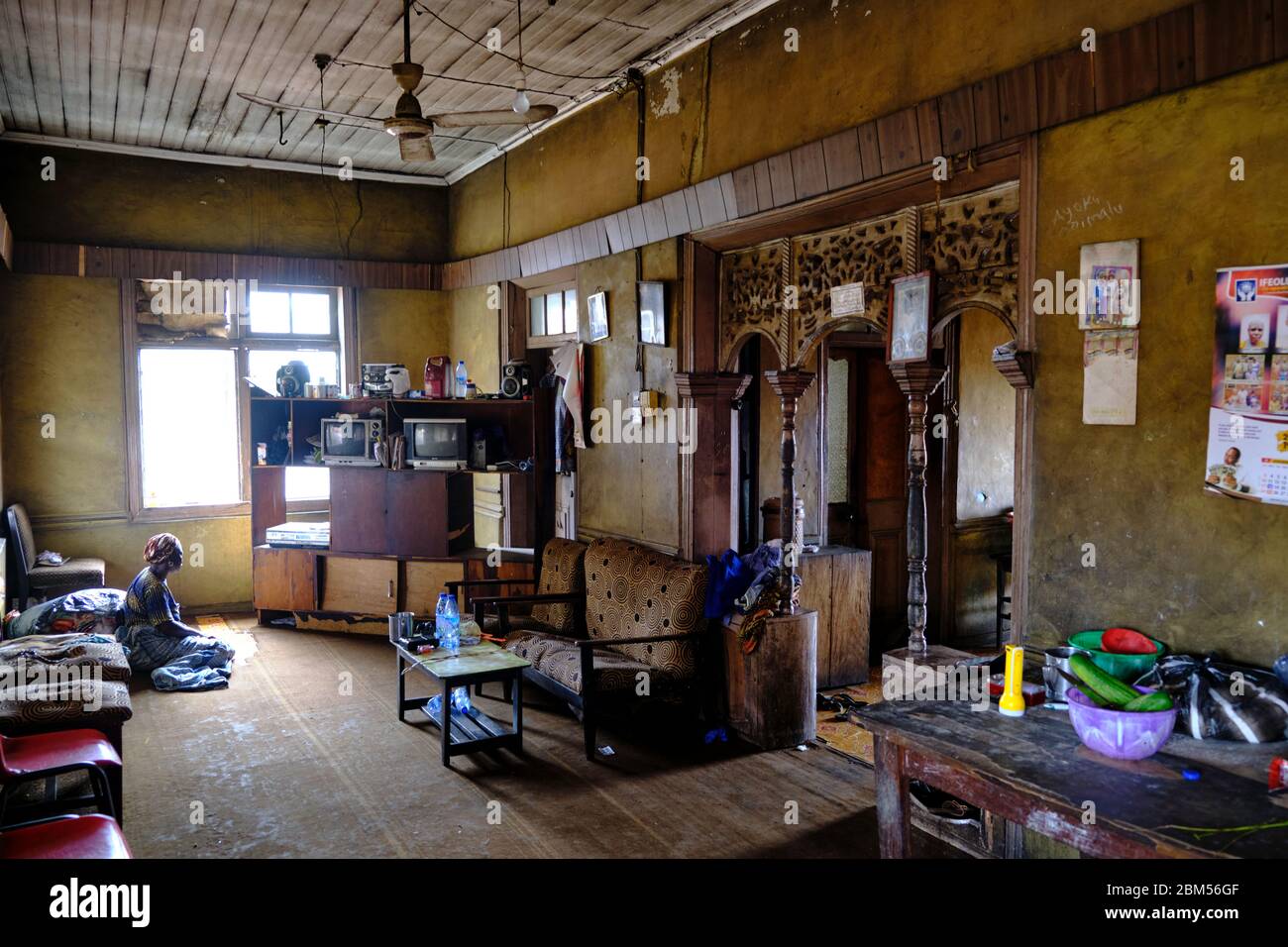 Frau, die aus dem Fenster auf ihr Haus in Abeokuta schaut. Stockfoto