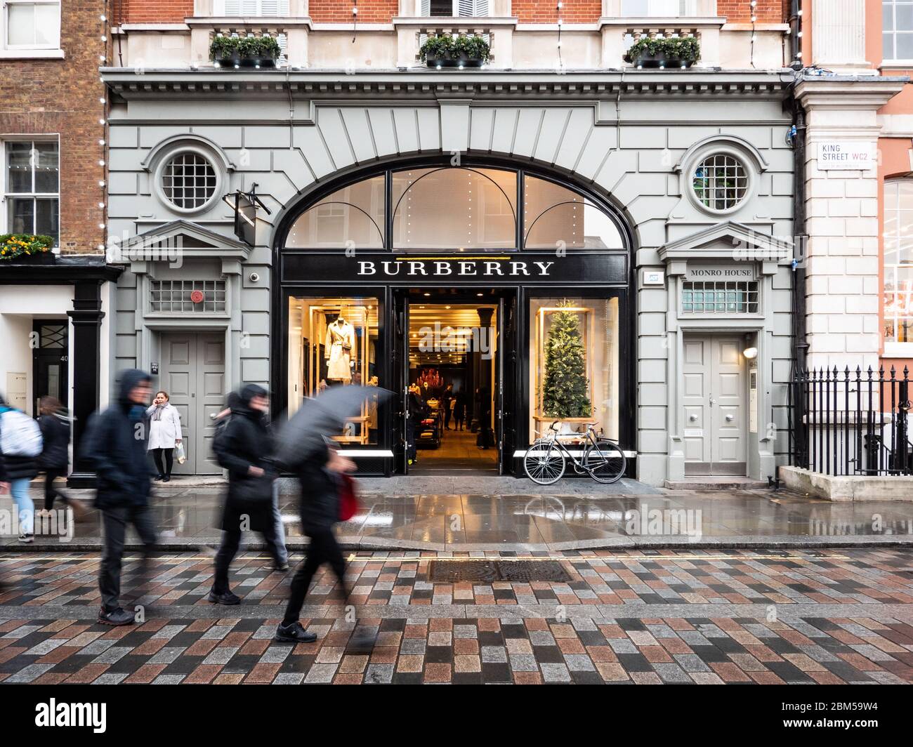 Burberry Store, Covent Garden. An einem regnerischen Tag spazieren die Shopper an der façade zum führenden Modegeschäft im Londoner Modeviertel West End. Stockfoto