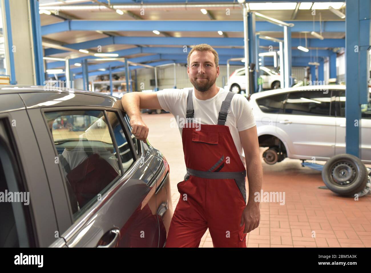 Porträt eines lächelnden Automechanikers in einer professionellen Werkstatt - Nahaufnahme Foto Stockfoto