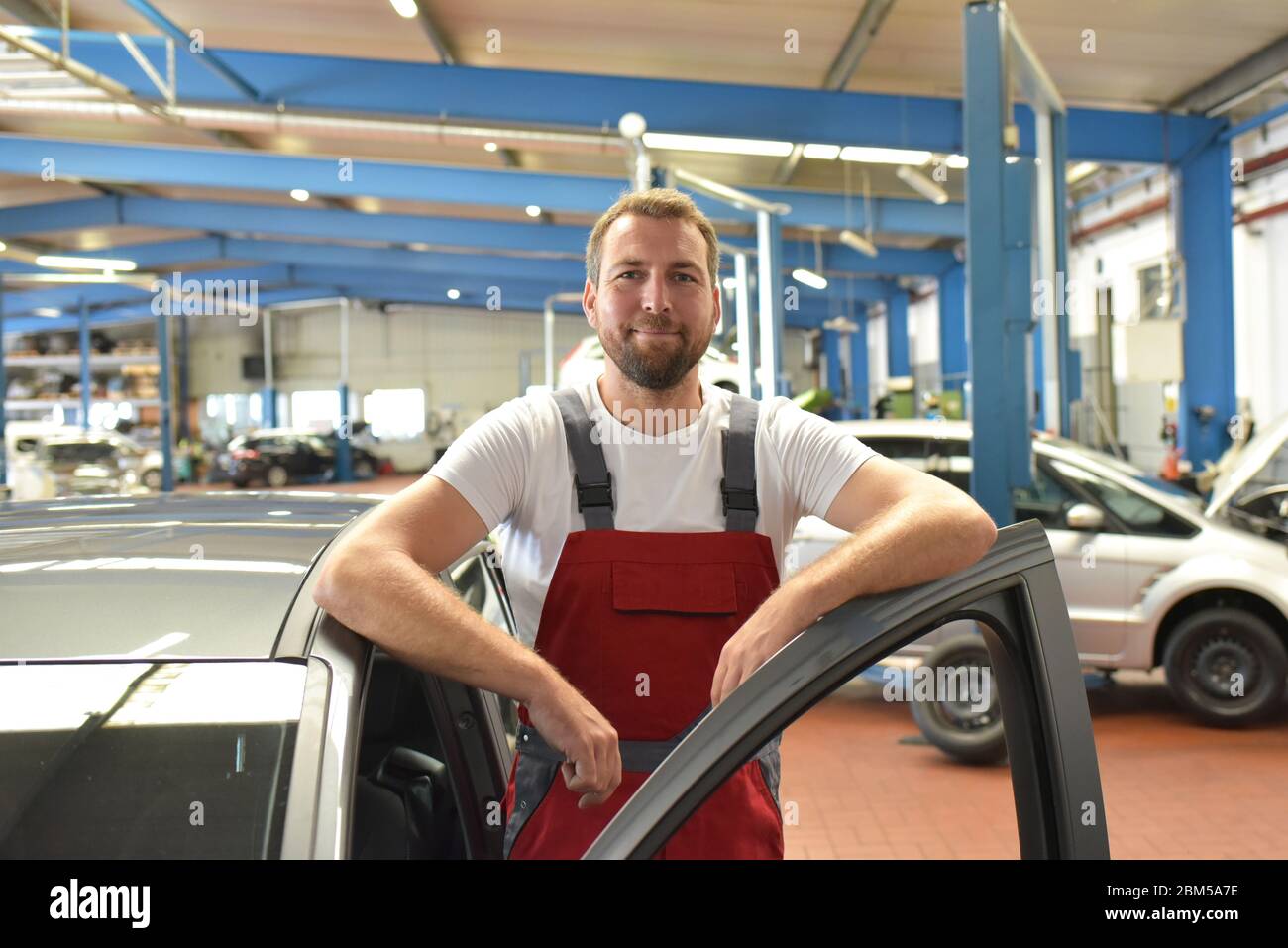 Porträt eines lächelnden Automechanikers in einer professionellen Werkstatt - Nahaufnahme Foto Stockfoto