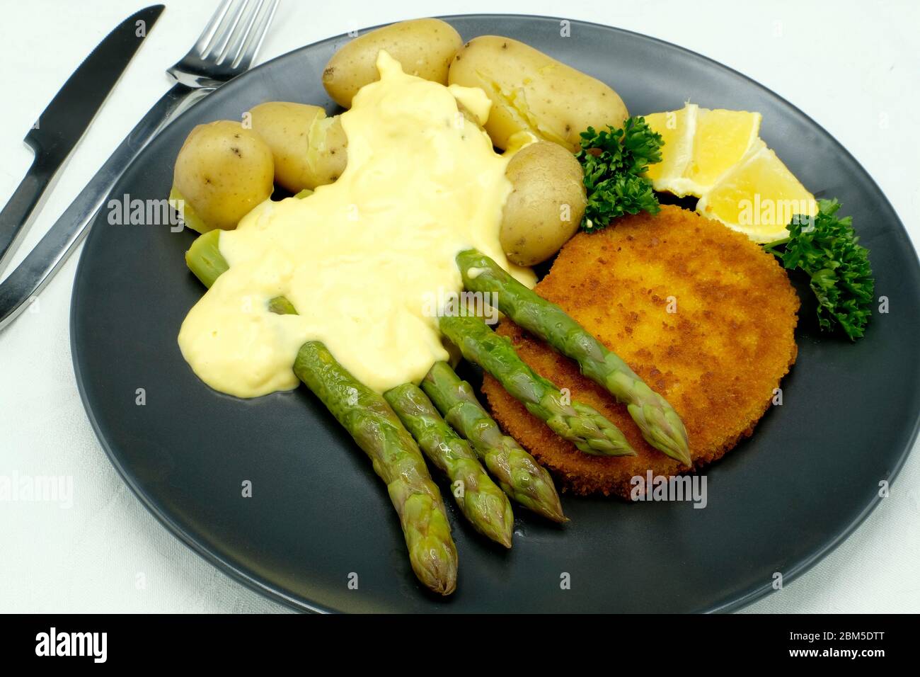 Spargel mit Schnitzel, neuen Kartoffeln und einer Sauce Hollandaise Stockfoto