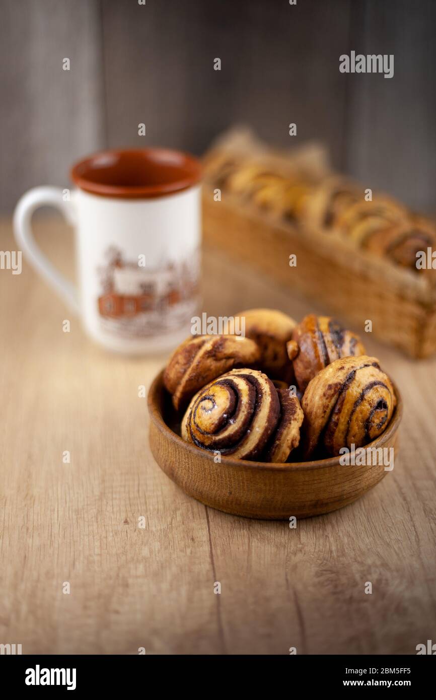 Runde hausgemachte Kekse auf dem Tisch. Gestreifte Plätzchen mit Kakao und Zimt. Leckere Brötchen für eine Tasse Kaffee zum Frühstück. Holzhintergrund innen Stockfoto