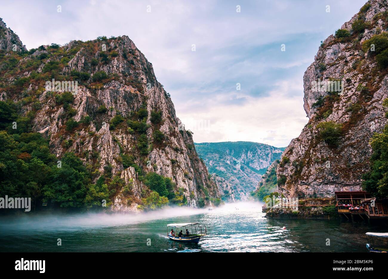 Matka, Nordmakedonien - 26. August 2018: Canyon Matka bei Skopje, mit Kajakfahrern und magischer nebliger Landschaft mit ruhigem Wasser Stockfoto