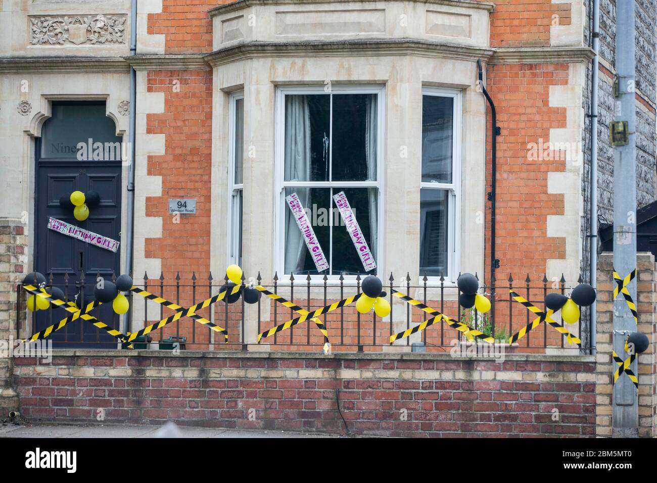 Geburtstagsfeier Dekorationen während Coronavirus Sperrung mit gelben und schwarzen Gefahrenband auf einem Haus in Penarth, Wales, Mai 2020. Stockfoto